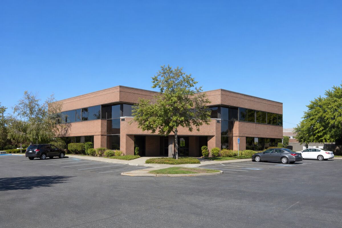 Exterior of a two-story suburban brick office building with parking
