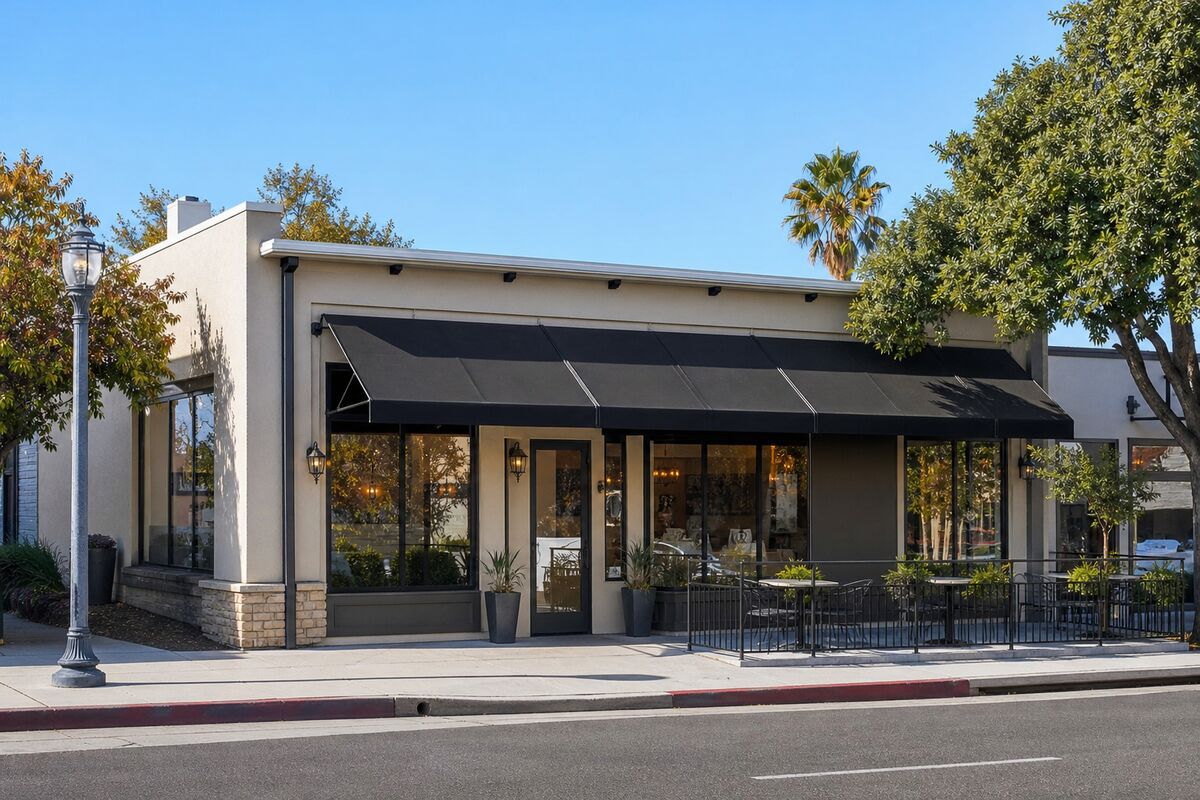 Exterior of a restaurant storefront with an awning and patio seating